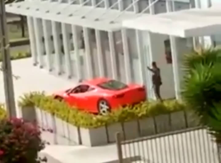 Guy breaks Ferrari showroom glass while parking