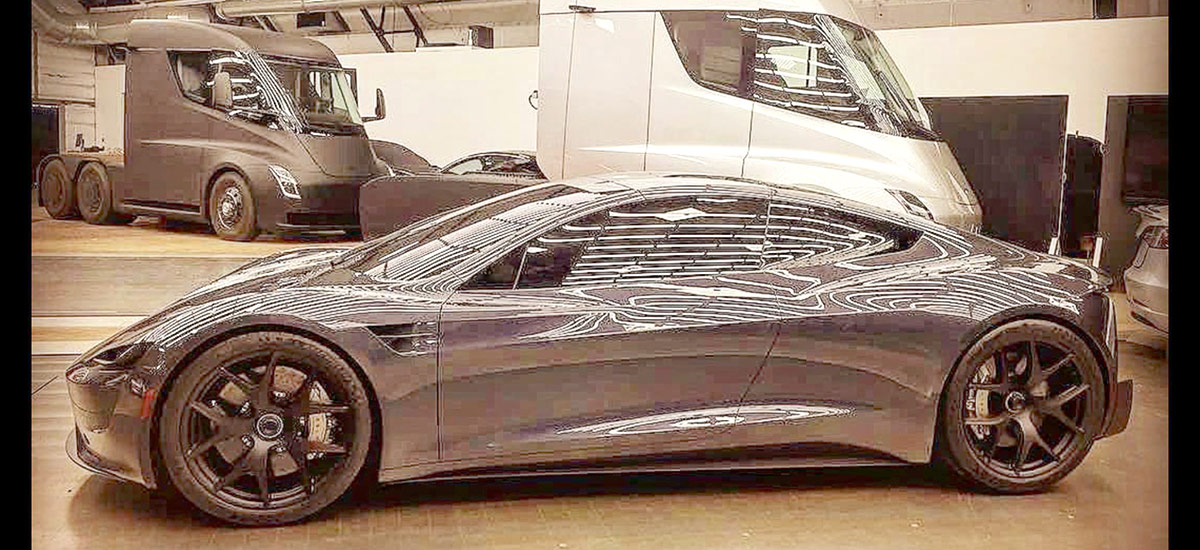 Tesla Roadster leaked photo from inside Tesla factory. Tesla Semi trucks also in background.