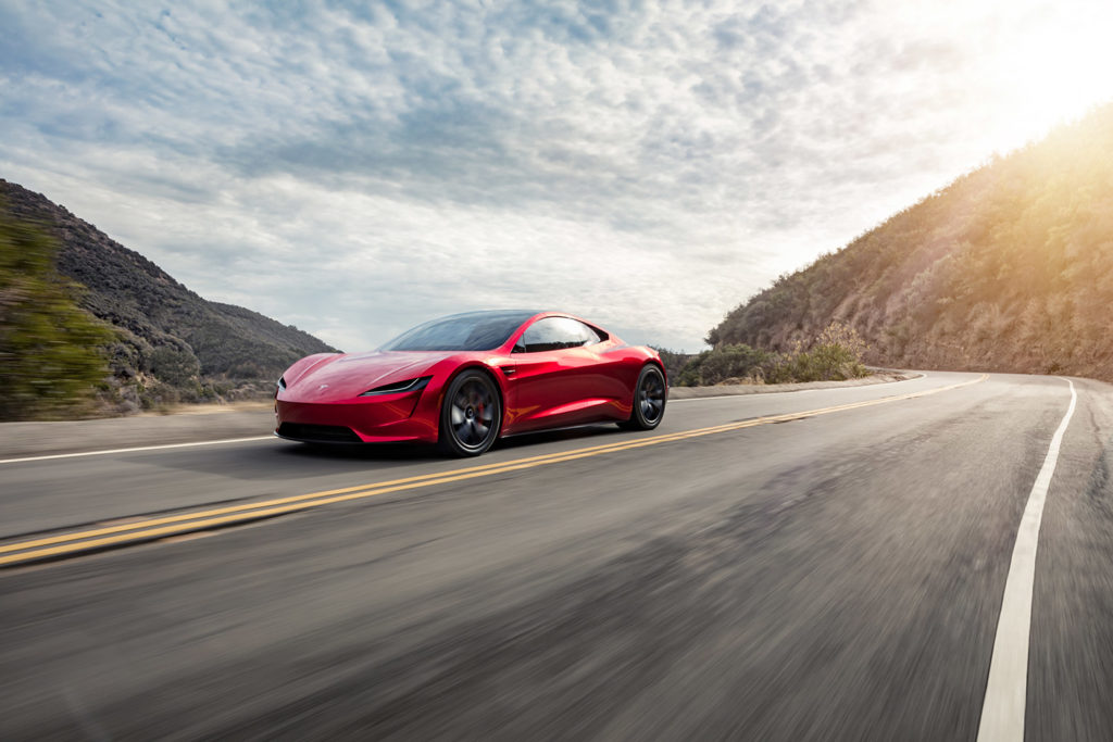 Tesla Roadster in red color - racing on the mountains