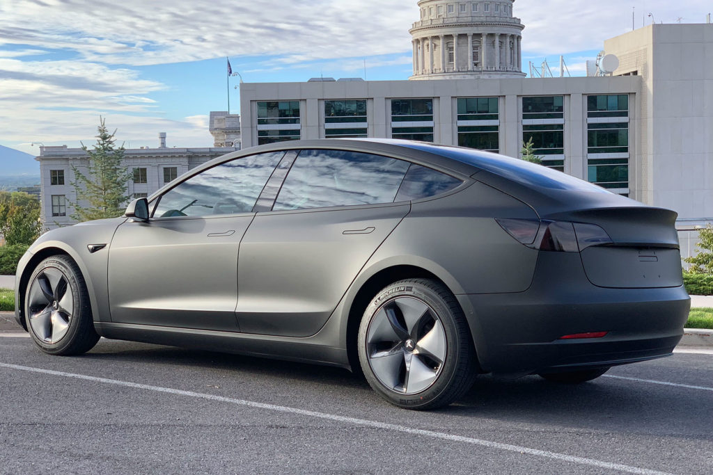 Tesla Model 3 wrapped in matte black, side rear view