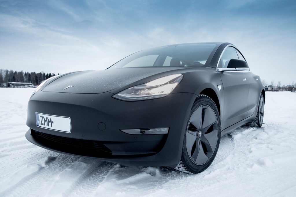 Matte Black Tesla Model 3 in Hämeenlinna, Finland, standing in snow at the golden hour.