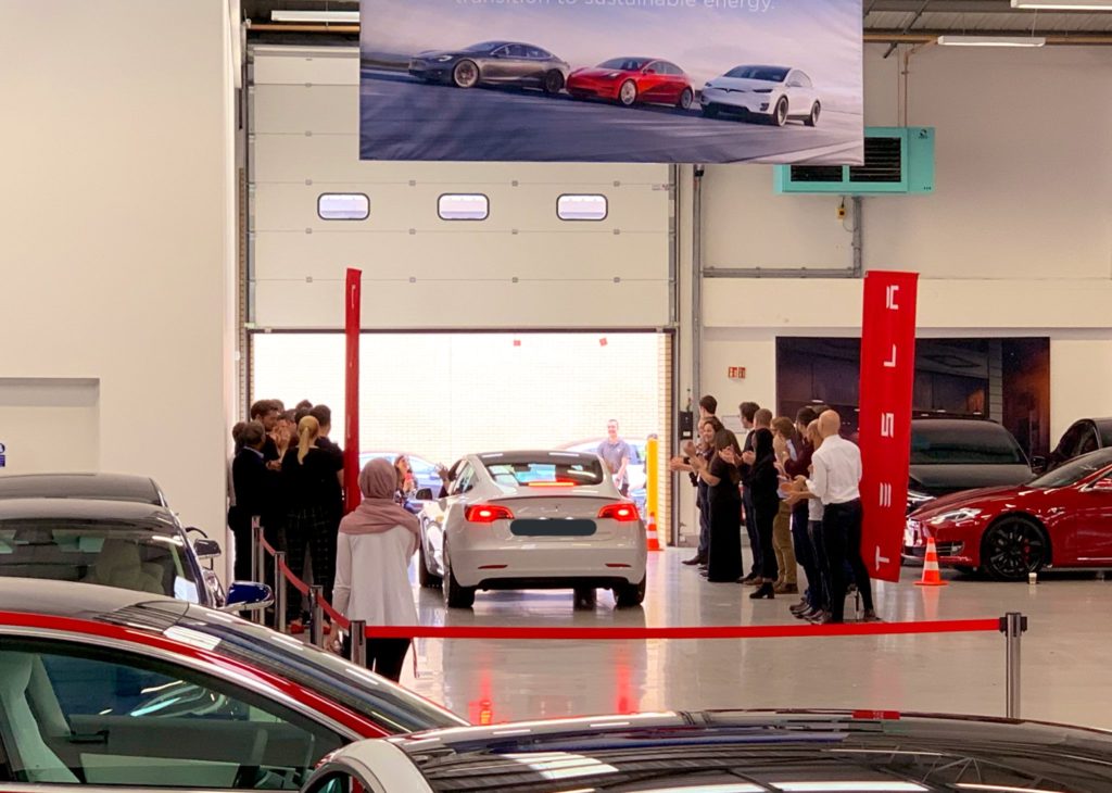 Tesla staff greeting the first RHD Model 3 owner upon leaving the showroom.