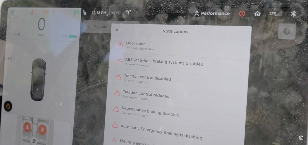 Tesla Model 3 Drifting: Center touchscreen showing list of safety and stability features disabled as caution.