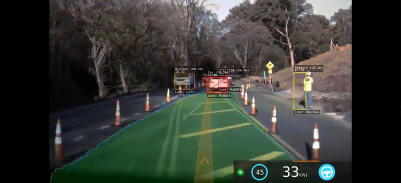 Tesla Autopilot vision in a construction zone with traffic cones on both sides.