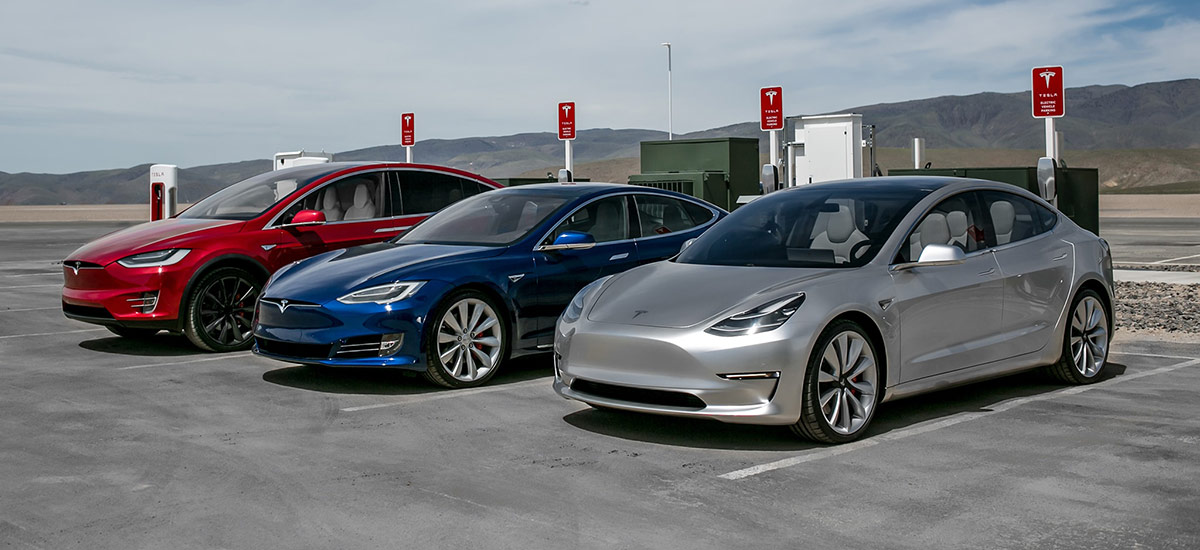 Tesla Model 3, S, and X at a Supercharger station.